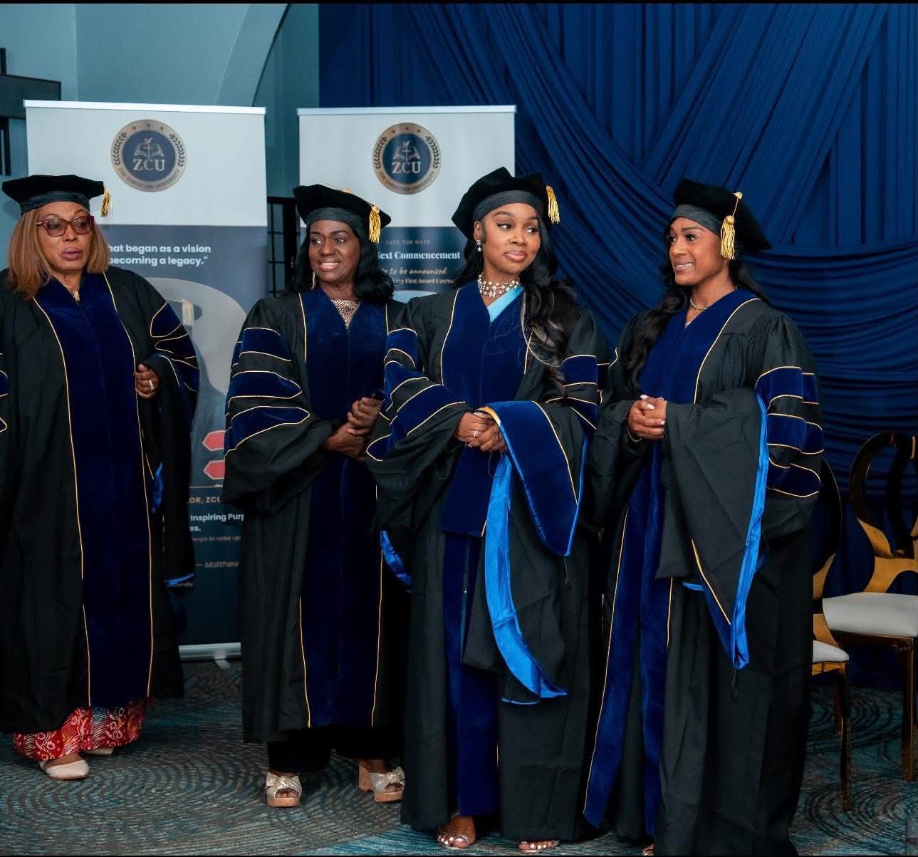 Four graduates standing together on stage at commencement