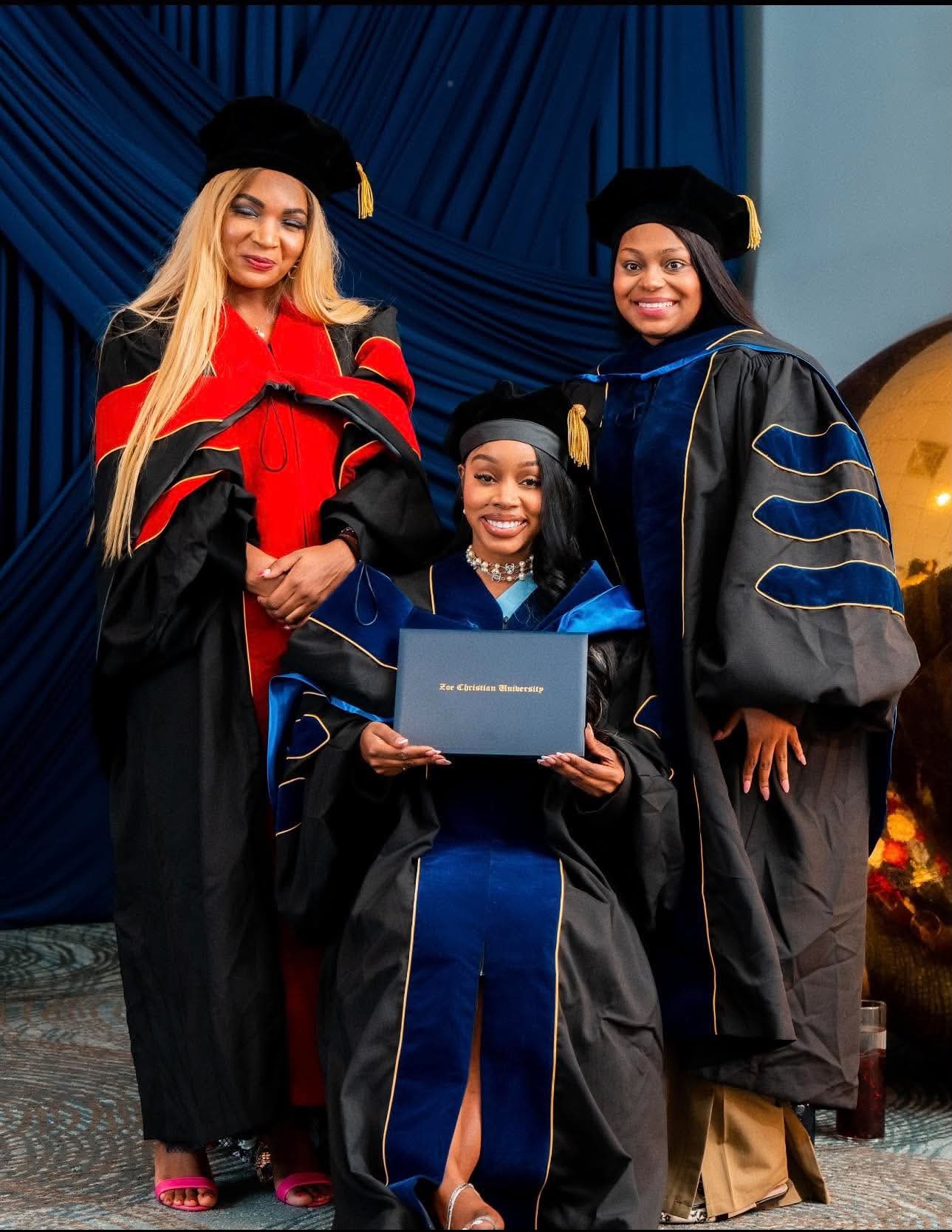 Graduate holding her Zoe Christian University diploma with two faculty members