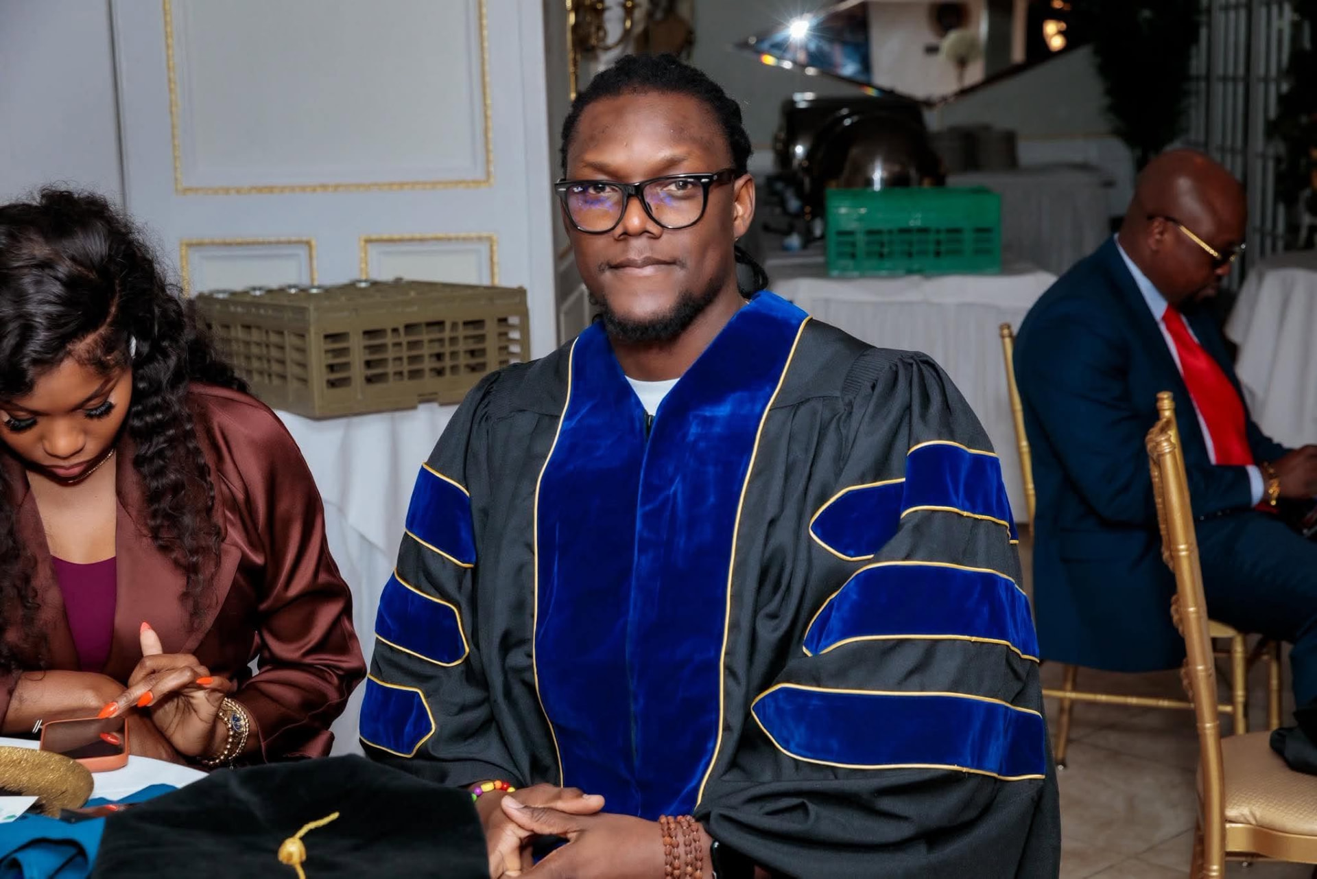 A Zoe Christian University student in regalia seated at commencement
